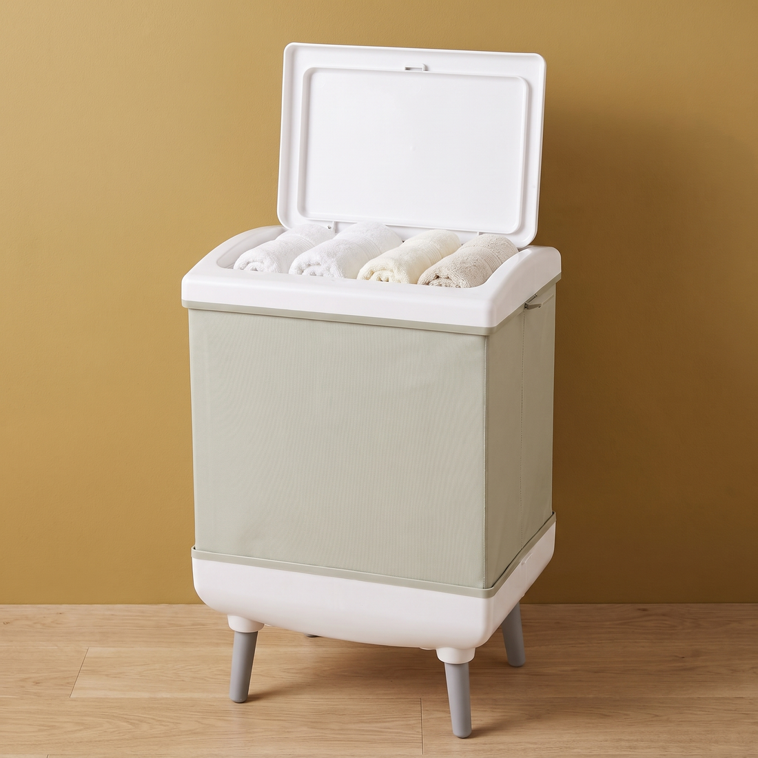 The Fold-Away Spa towel warmer with rolled towels against a gold wall