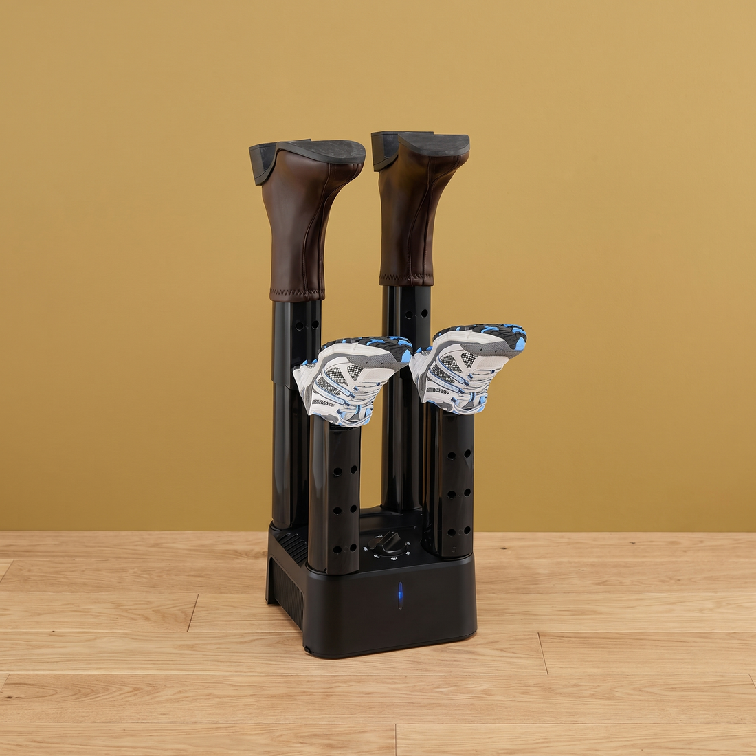The Boot Tree electric boot dryer holding boots and sneakers on a gold wall